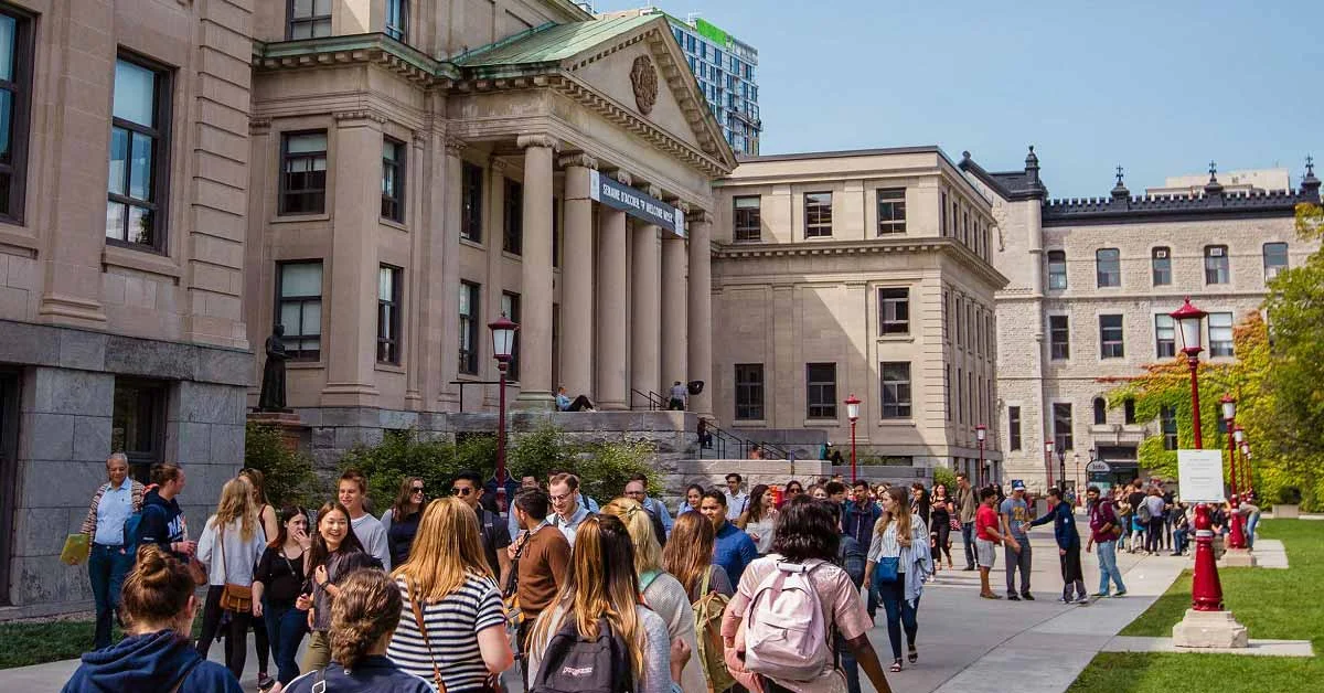 Students crossing the courtyard in front of Tabaret Hall at the University of Ottawa on a clear day